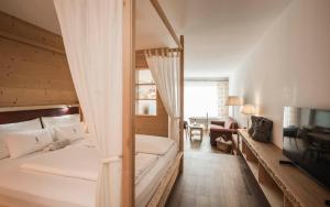 a bedroom with a bunk bed and a living room at Alpenheim Charming & Spa Hotel in Ortisei +71 photos