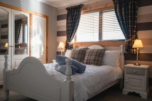 a bedroom with a white bed and a window at Wildeston in Thurso