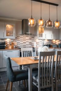 a kitchen with a wooden table and chairs at Wildeston in Thurso