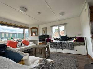a living room with two couches and a balcony at Stable Lodge in Williton