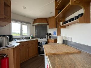 a kitchen with wooden cabinets and a counter top at Stable Lodge in Williton +22 photos