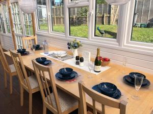 a wooden table with chairs and a bottle of wine at Stable Lodge in Williton