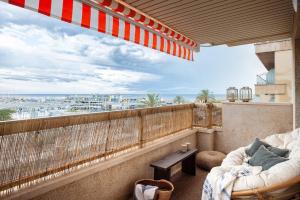 a balcony with a couch and a view of the ocean at Impressive beachfront home in Calafell