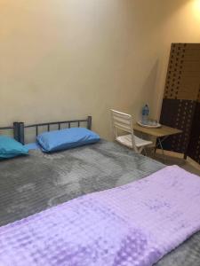 a bedroom with two beds and a table with a chair at Heritage Hostel Muscat in Muscat +66 photos