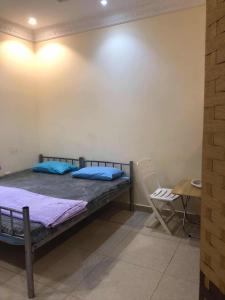 a bedroom with a bed and a table and a chair at Heritage Hostel Muscat in Muscat
