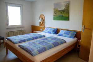 a bedroom with a large bed with blue pillows at Ferienweingut Kreuz-Bauer in Minheim
