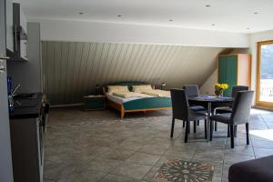 a room with a bed and a table and chairs at Ferienweingut Kreuz-Bauer in Minheim
