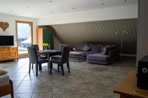 a living room with a couch and a table and chairs at Ferienweingut Kreuz-Bauer in Minheim