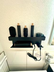 a black shelf on the wall with a hair dryer at LH Apartments Aulendorf in Aulendorf