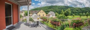 a balcony with a table and a view of a garden at Ferienweingut Kreuz-Bauer in Minheim
