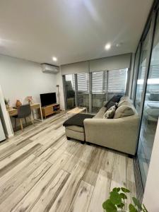 a living room with a couch and a television at One bedroom Oasis in Strathfield in Sydney