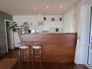 a kitchen with a bar with two stools at Къща за гости Пъстрина in Sŭbotkovtsi +19 photos