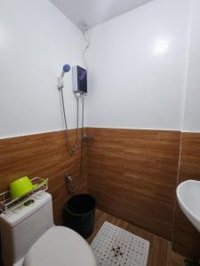 a bathroom with a toilet and a sink at Caishen Apartelle The Traveler Accomodation in Biga