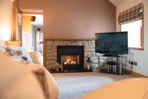 a living room with a fireplace and a tv at Wildeston in Thurso