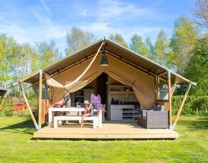 a woman sitting at a table in a yurt at ZEcamping 3 étoiles pet friendly avec sauna bar et restaurant in Priziac
