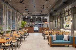 a restaurant with tables and chairs and a bar at Hill Berry - A SoVo Hotel in Lonavala