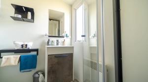a bathroom with a sink and a mirror at ZEcamping 4 étoiles familial avec piscine couverte in Laroque-des-Albères