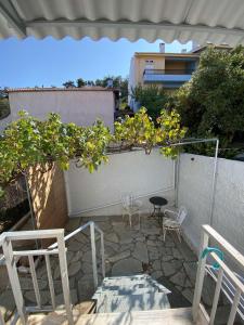 a patio with two chairs and a table and some plants at Studio Mytzela in Amaliapoli