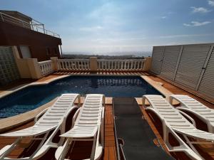 a swimming pool with lounge chairs on a balcony at BEACH HOUSE. CASA CON PISCINA PRIVADA in Calafell +68 photos