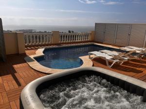 a swimming pool on the deck of a building with chairs at BEACH HOUSE. CASA CON PISCINA PRIVADA in Calafell