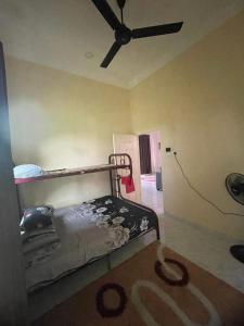 a bedroom with a bed and a ceiling fan at Ramly Homestay in Kuala Terengganu