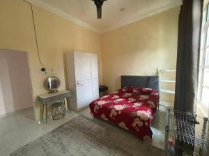 a bedroom with a bed and a small table at Ramly Homestay in Kuala Terengganu