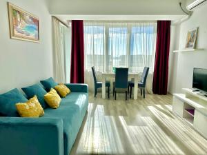 a living room with a blue couch and a table at Dolce Aqua Summerland Apartments in Mamaia