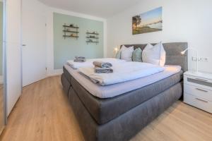 a bedroom with a large bed with white sheets at Fewo Resaleen in Öhningen
