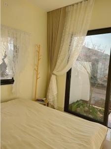 a bedroom with a bed and a large window at Hannie House- Mộc Châu in Mộc Châu