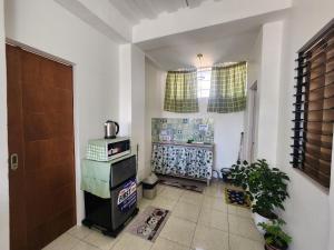 a living room with a refrigerator and a window at Caishen Apartelle 201 in Sabutan
