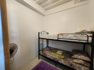 two bunk beds in a room with a fan at Caishen Apartelle 201 in Sabutan