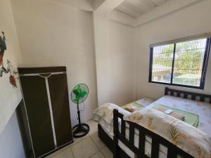 a small bedroom with a bed and a window at Caishen Apartelle 201 in Sabutan