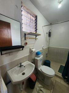 a bathroom with a white toilet and a sink at Caishen Apartelle 201 in Sabutan