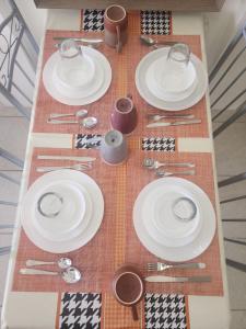 a table with white plates and utensils on it at Caishen Apartelle 201 in Sabutan