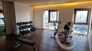 a gym with exercise equipment in a room with windows at Edifício Kings Tower T2-02 in Luanda