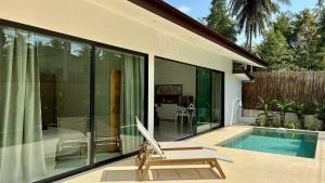 a house with a pool and a chair next to it at Samma Villas - Agate Villa - 1 BDR & private pool in Ko Phangan