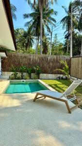 a white chair sitting next to a swimming pool at Samma Villas - Agate Villa - 1 BDR & private pool in Ko Phangan