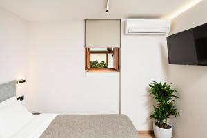 a bedroom with a bed and a window and a plant at Morfeas Hotel in Chania