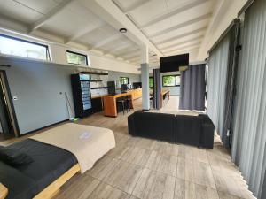 a room with a bed and a couch and a tv at Cabañas Kai Rau Tu in Hanga Roa