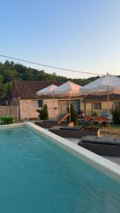 a swimming pool with blue water and umbrellas at Zaz HOME in Sasca Română