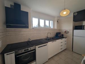 a kitchen with white cabinets and a black counter top at Villa jeandor in Braucourt +17 photos