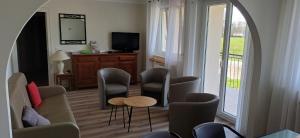 a living room with chairs and a table and a tv at Villa jeandor in Braucourt