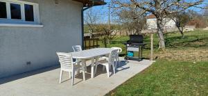 a table and chairs with a grill in a yard at Villa jeandor in Braucourt