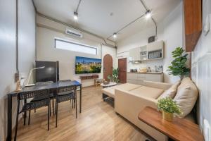 a living room with a couch and a desk at Swing By in Bangkok