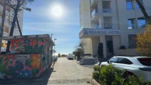 a street with cars parked in front of a building at Teddy Apartment in Durrës