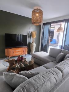 a living room with a couch and a flat screen tv at Stars Villa in Ngingas