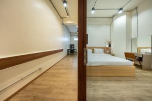 a bedroom with a bed and a desk and a sink at Swing By in Bangkok