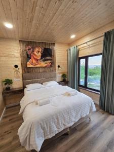 a bedroom with a large bed and a large window at Bella Vista Bungalow in Turda