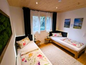 a small room with two beds and a window at Ferienhaus Haus im Garten in Feldkirch +23 photos