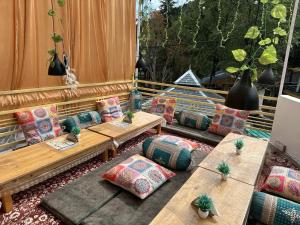 a patio with couches and tables and a window at OmiHomeStay Dharamkot McLeodganj in Dharamshala